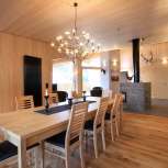 Helles Holzinterieur mit Esstisch und Kamin im Haus Ochsenkopf in Malbun, Liechtenstein