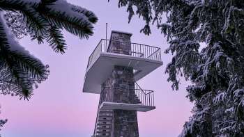Zwei Personen genießen die Aussicht vom Aussichtspunkt Gaflei über das Rheintal in Liechtenstein bei klarem Wetter.