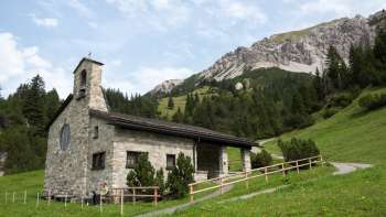 Friedenskapelle mit Berglandschaft im Hintergrund Friedenskapelle mit Berglandschaft im Hintergrund