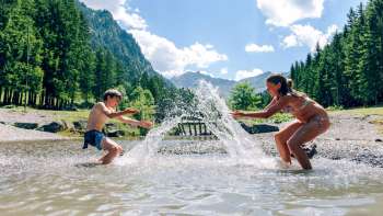 Kinder planschen im Gänglesee in Steg