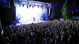 Große Menschenmenge vor beleuchteter Bühne beim Open-Air-Konzert Vaduz Soundz 2024 in Liechtenstein