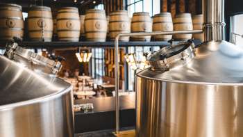 Blick von oben auf Brauereianlage mit Sudkesseln und Holzfässern im Liechtensteiner Brauhaus