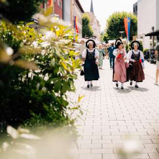 Frauen in traditionellen Trachten beim Staatsfeiertag 2024 in Vaduz, Liechtenstein, bei sonnigem Wetter