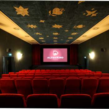 Innenraum des Altes Kino Vaduz mit rotem Samt und beleuchteter Leinwand