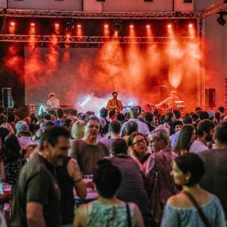 Konzert der Band Baba Shrimps beim FL1.LIFE Festival mit roter Bühnenbeleuchtung und großem Publikum