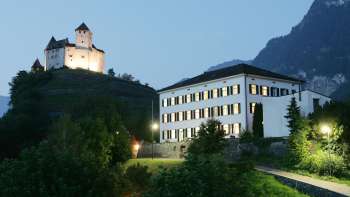 Abendlicher Blick auf das Haus Gutenberg mit der Burg Gutenberg im Hintergrund