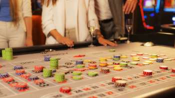 Gäste am Spieltisch beim Setzen ihrer Jetons im Casino Admiral Triesen, umgeben von spannender Casino-Atmosphäre.