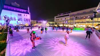 Schlittschuhlaufen bei Nacht auf der bunt beleuchteten Eisfläche von „Vaduz on Ice“ im festlich geschmückten Stadtzentrum.