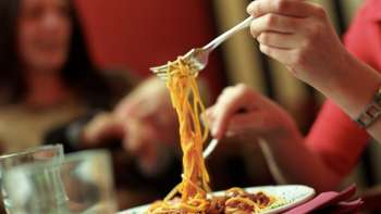 Person hebt mit der Gabel Spaghetti von einem Teller in der Brasserie Burg