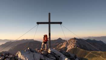 Wanderin beim Gipfelkreuz auf dem Augstenberg
