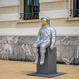 Seitliche Ansicht einer silbernen Astronauten-Skulptur mit goldfarbenem Visier bei der Bad Ragartz Ausstellung in Vaduz