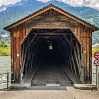 Eingang zur Alten Rheinbrücke Vaduz–Sevelen – denkmalgeschützte Holzbrücke als Fuß- und Radweg zwischen Liechtenstein und der Schweiz.
