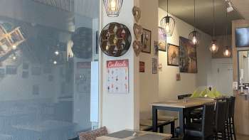 Stilvoll eingerichteter Gastraum mit schwarzen Holzmöbeln, Holzböden und kreativer Wanddekoration