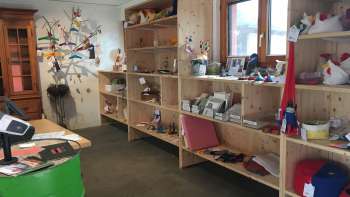 Innenraum des Birkahoflädile mit Holzregalen voller regionaler Produkte, dekorativ gestaltet mit bunten Elementen – Hofladen in Liechtenstein.