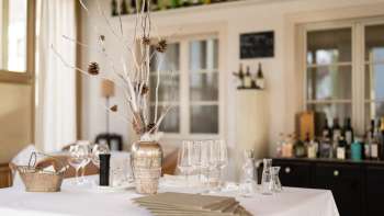 Dekorative Bar im Restaurant Vivid mit stilvollen Gläsern, Flaschen und natürlicher Lichtstimmung