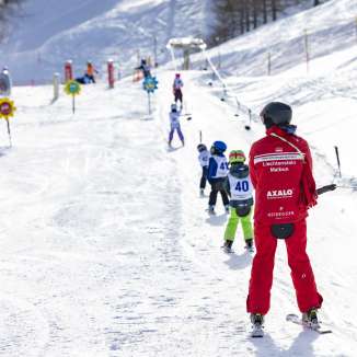 Skilehrer begleitet Kinder auf dem Übungslift in Malbun – ideales Skigebiet für Familien und Einsteiger in Liechtenstein.