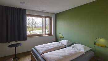 Zweibettzimmer mit grün gestrichener Wand in der Jugendherberge Schaan-Vaduz