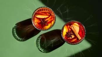 Mit Glühwein gefüllte Gläser auf einem grünen Tisch