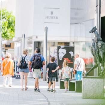 Menschen spazieren durch die moderne Fussgängerzone von Vaduz vorbei am Kunstmuseum