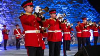 Blasmusik-Ensemble in auffälligen roten Uniformen beim Princely Tattoo 2022 in Liechtenstein – festlicher Auftritt mit traditionellen Klängen.