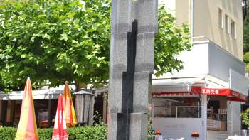 Skulptur „Monoform 29“ von Gottfried Honegger aus grauem Stein mit vertikalem Einschnitt – moderne Kunst in Vaduz.