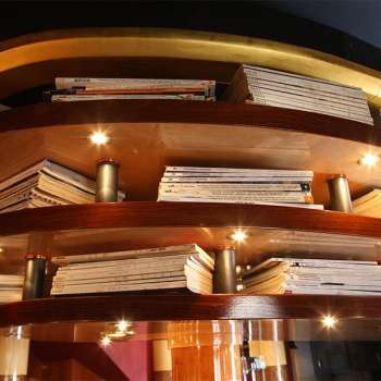 Holzregal mit illuminierten Büchern als Deckenverkleidung