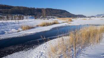 Herbstlicher Egelsee in Mauren mit Spiegelung im Wasser und Sicht auf das Dorf in der Ferne.