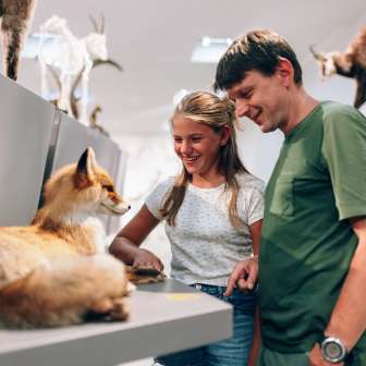 Vater und Tochter betrachten ein ausgestopftes Tier im Liechtensteinischen LandesMuseum