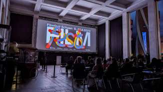 Besucher sitzen beim Filmfest Schaan 2023 vor der Leinwand in einer modernen Abendkulisse in Liechtenstein