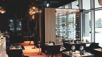 Modernes Restaurantinterieur mit eleganten schwarzen Tischen und Stühlen