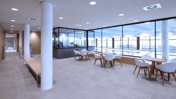 Heller Sitzbereich im Hallenbad Triesen mit Blick auf das Schwimmbecken durch Glasfront.