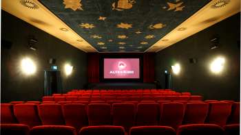 Innenraum des Altes Kino Vaduz mit rotem Samt und beleuchteter Leinwand