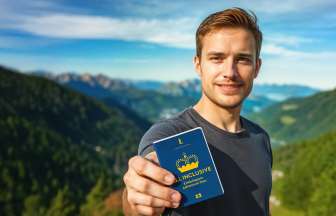 ALL INCLUSIVE Erlebnispass Mann zeigt den ALL INCLUSIVE Erlebnispass mit Bergpanorama im Hintergrund