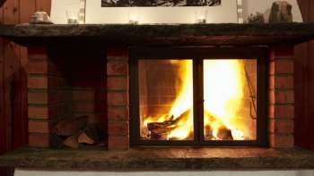 Warmer Kamin mit brennendem Holz und stimmungsvollem Licht