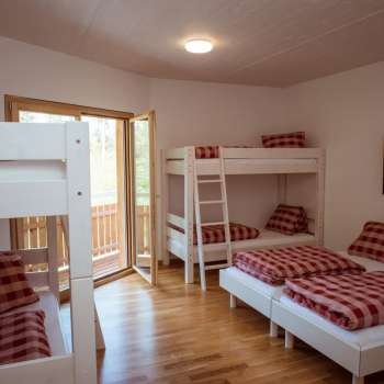 Familienfreundliches Mehrbettzimmer mit Etagenbetten und Einzelbetten im Gästehaus beim Camping Mittagsspitze.