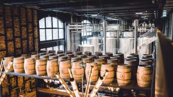 Sudkessel und Holzfässer im stilvollen Innenraum der Braustube des Liechtensteiner Brauhauses