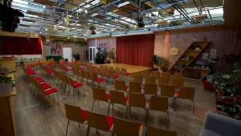 Grosser, lichtdurchfluteter Veranstaltungsraum der Kreativ Akademie mit Bühne